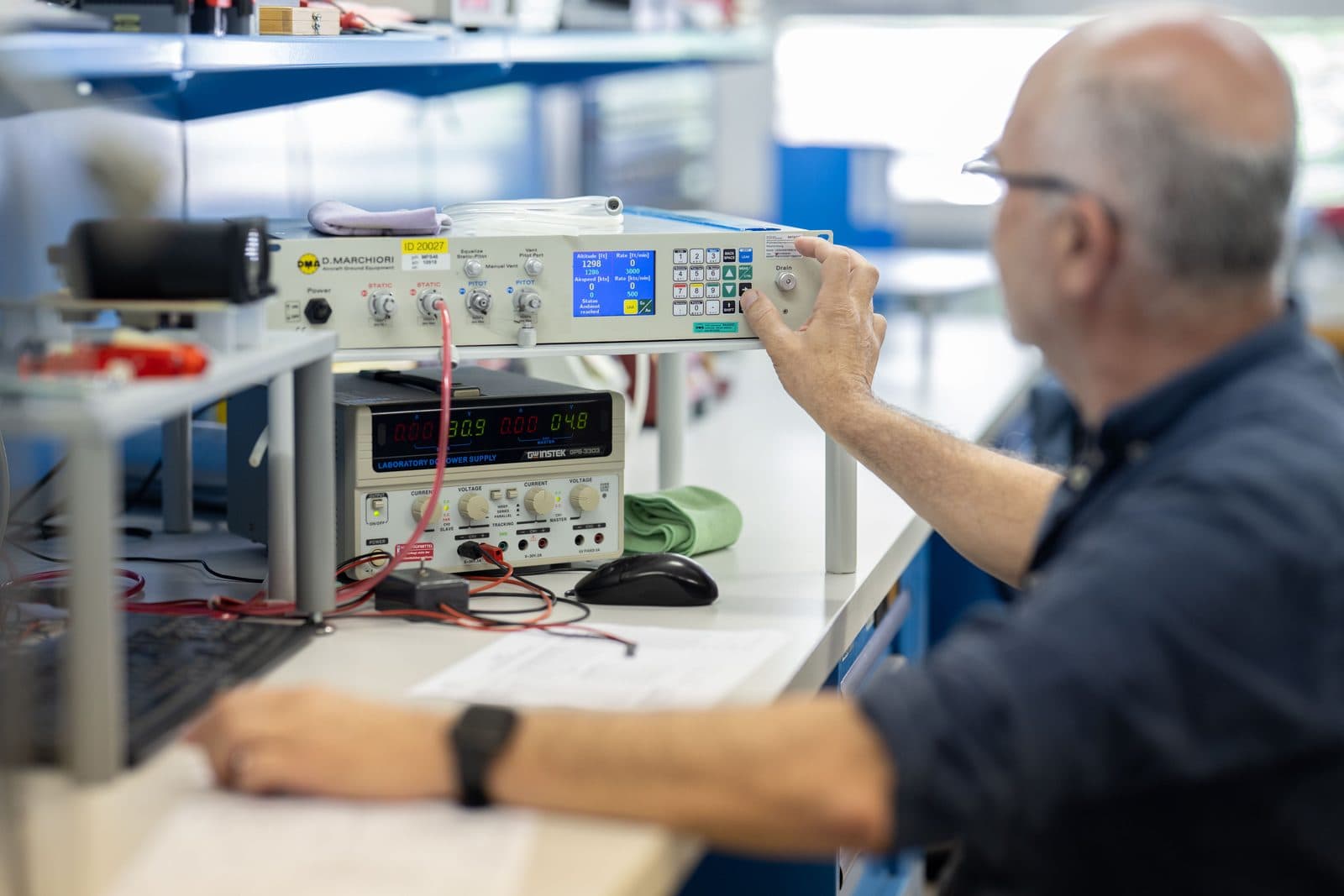 SATHOM technician calibrating an instrument on a pitot static test bench